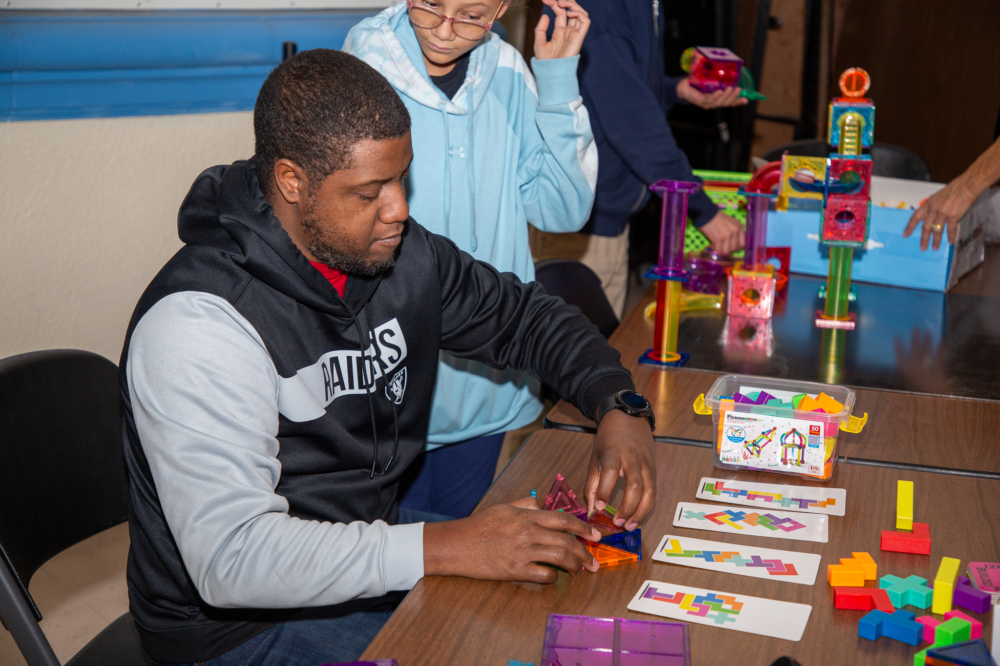 A teen boy plays with colorful kinetic blocks