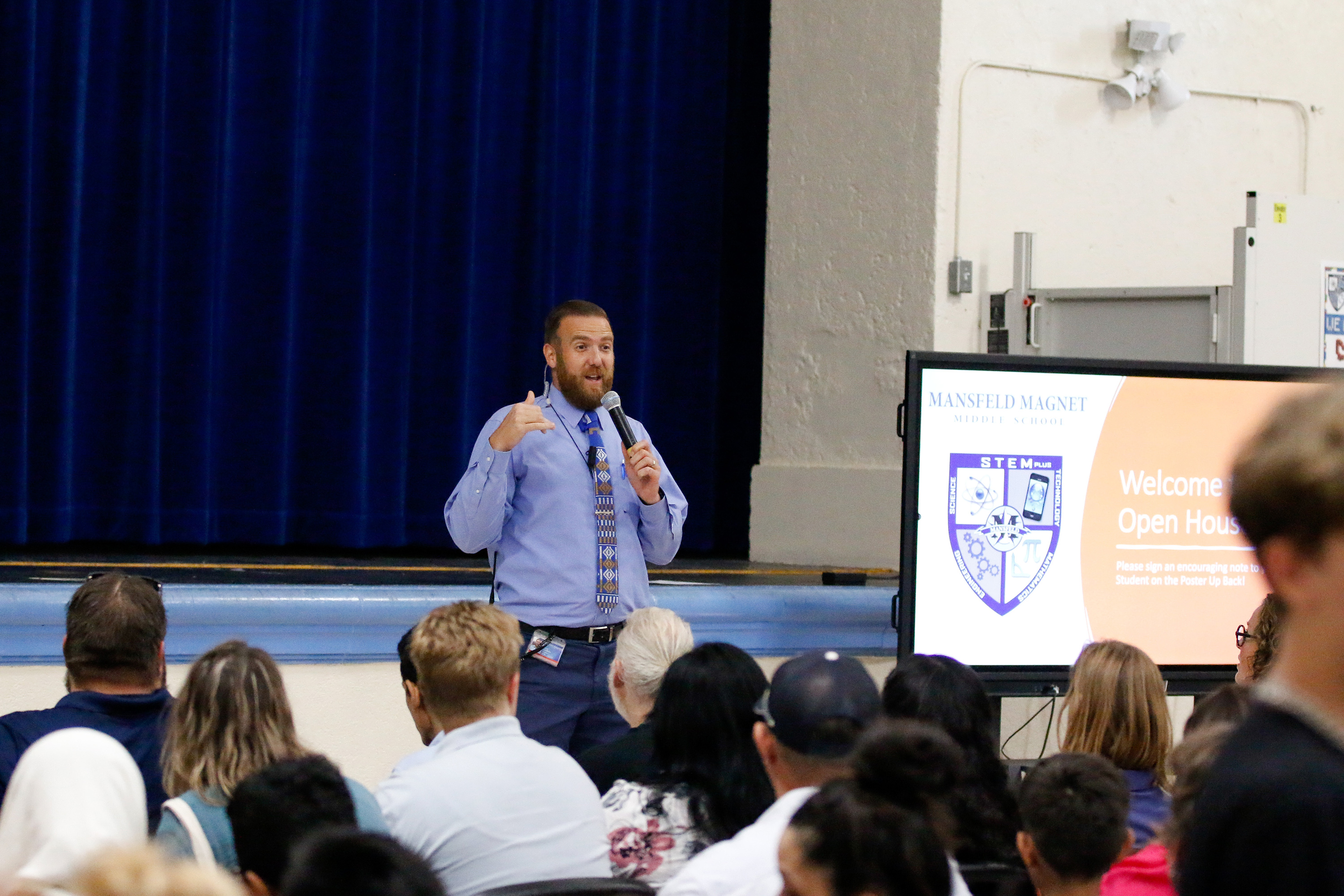 Mansfeld's principal stands in front of the cafeteria talking to families at the open house