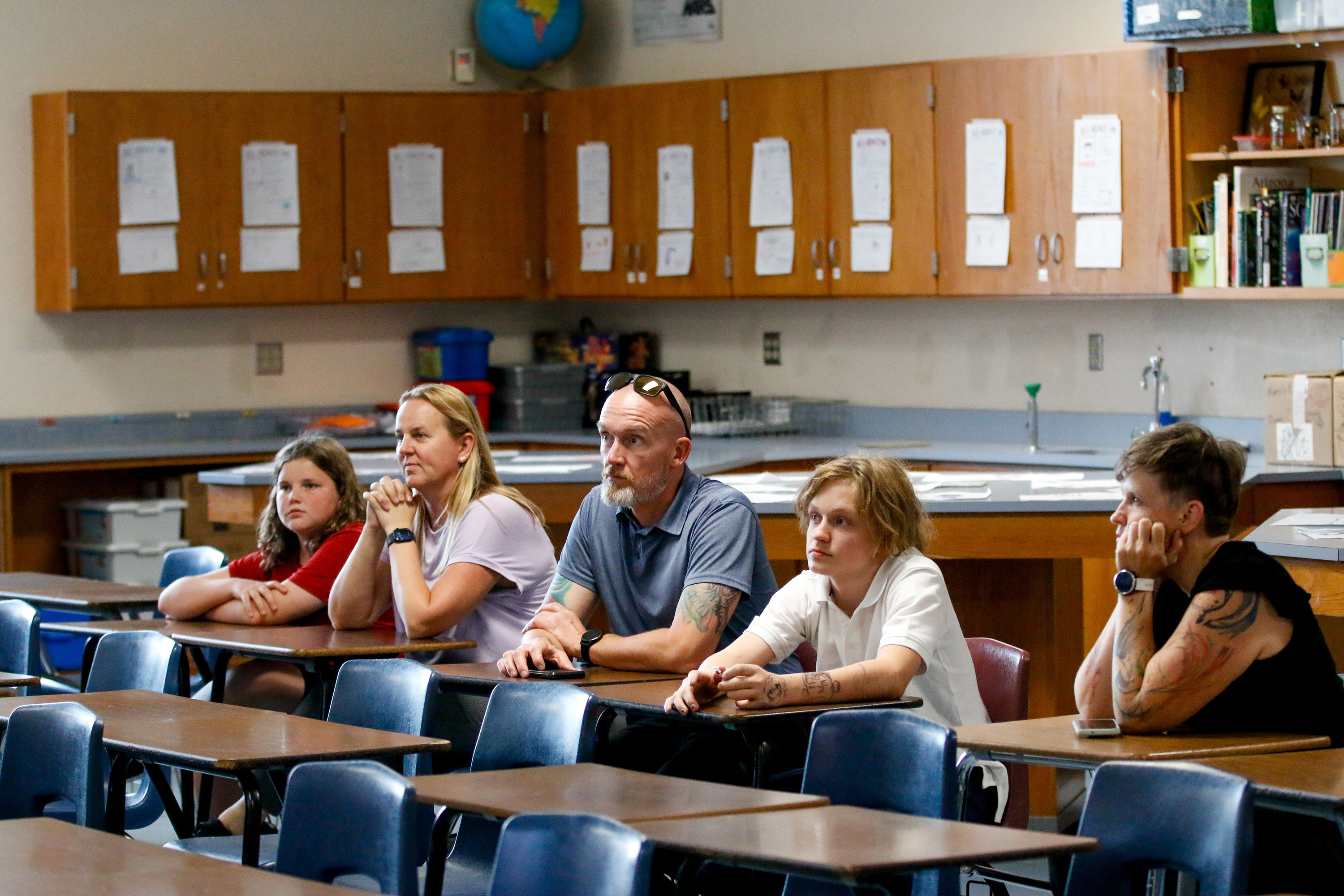 A family listens intently in a classroom