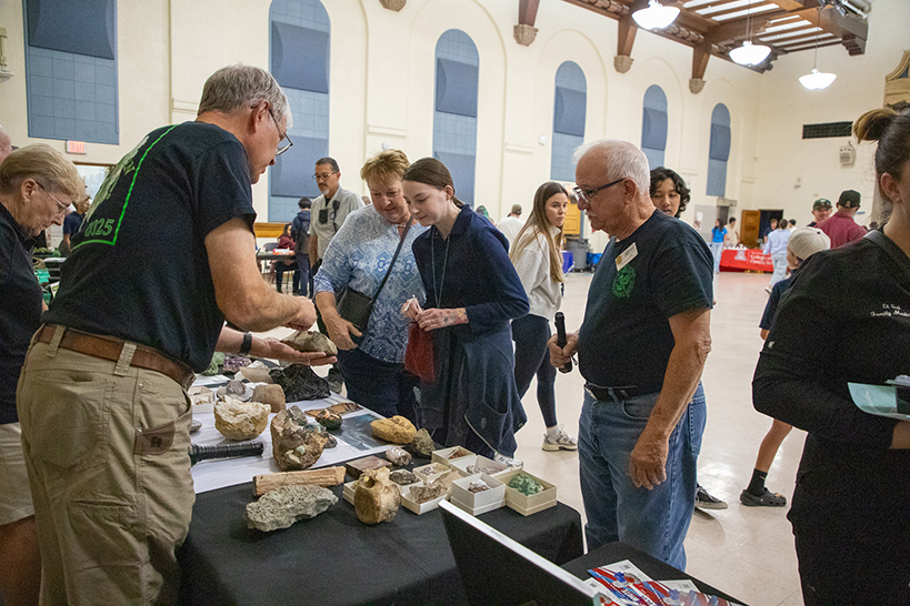 A man shows off some rocks to a family