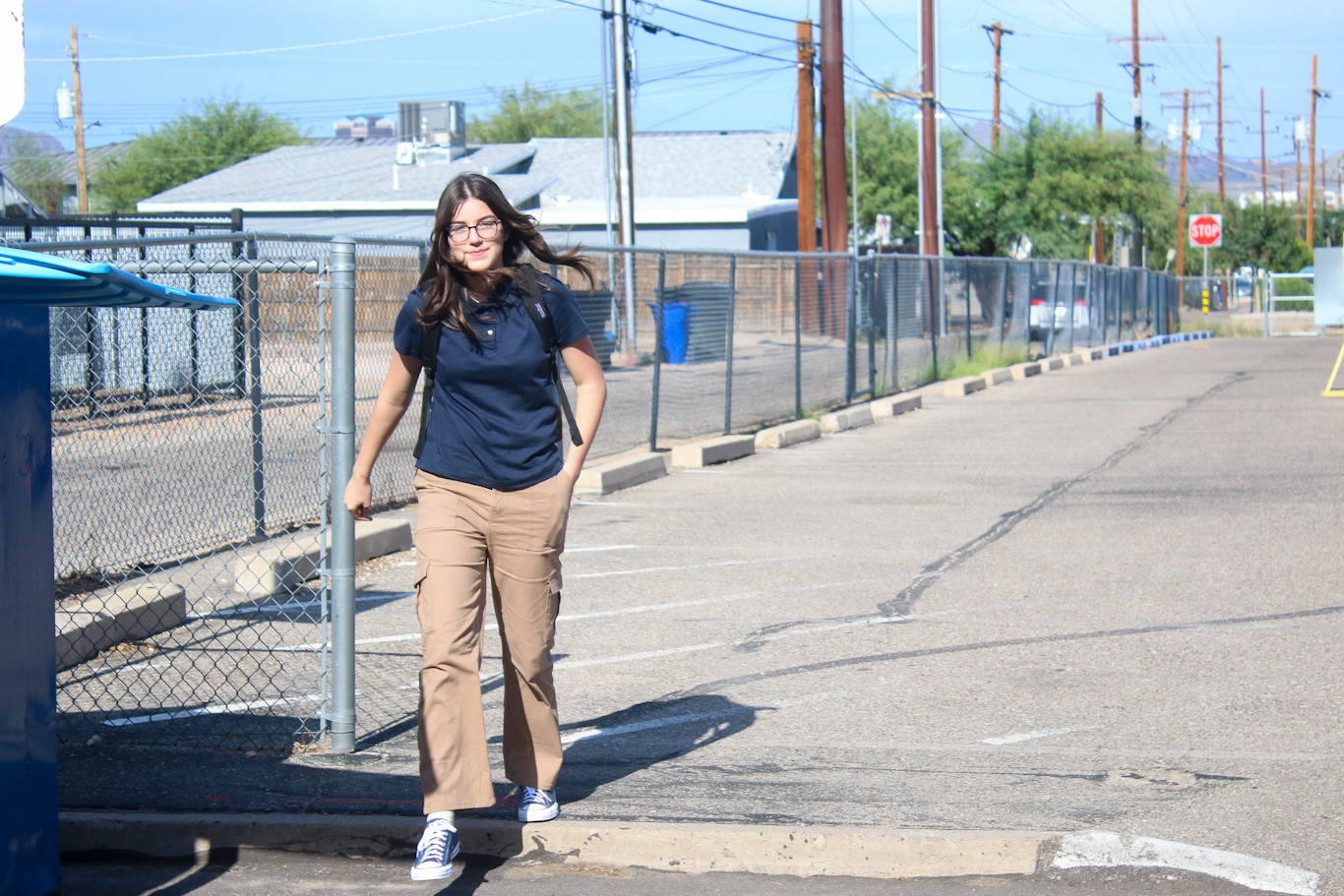 A preteen girl smiles as she walks to school on the first day