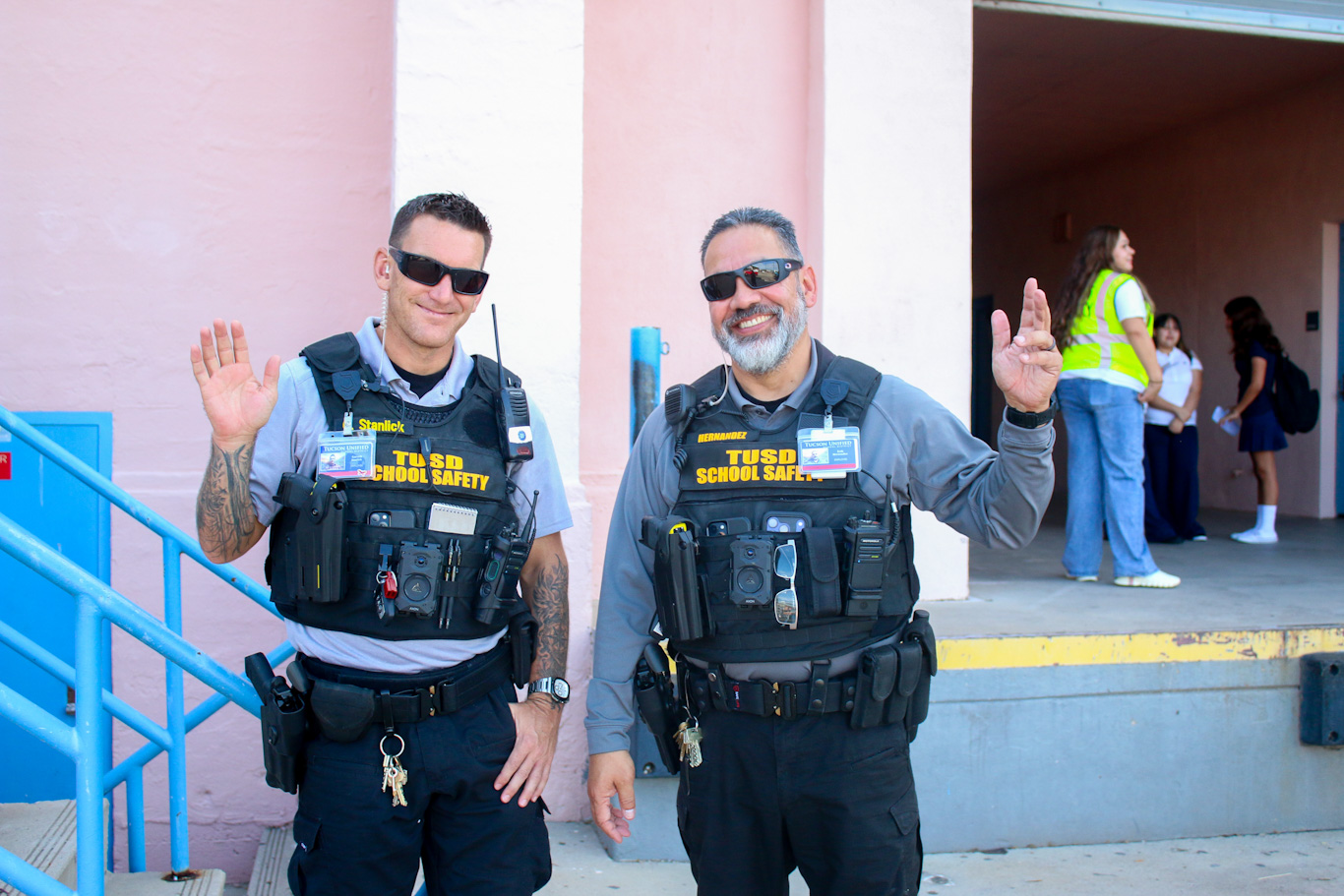 Two School Safety officers wave