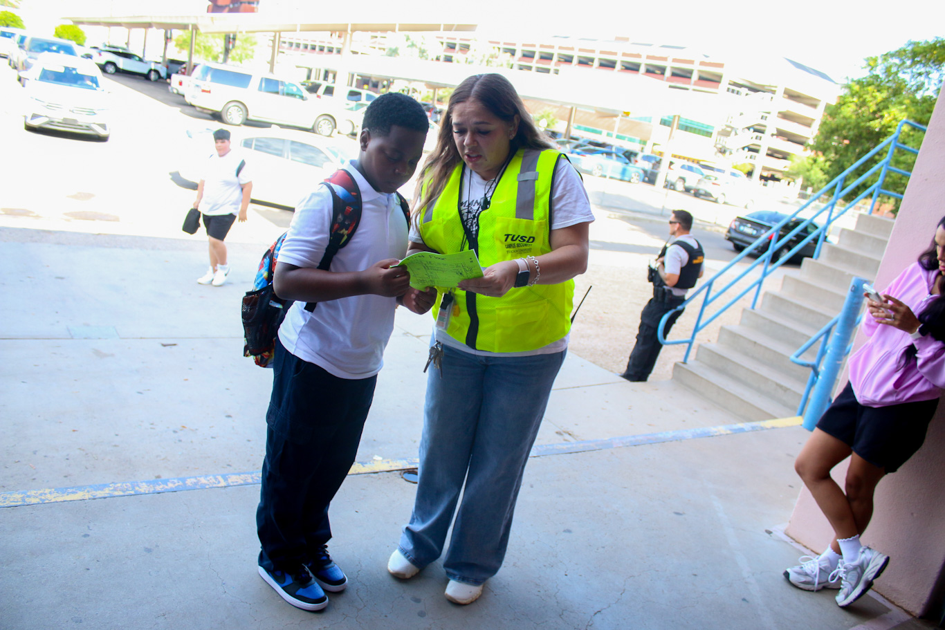A School Safety employee helps a student with a map of the campus