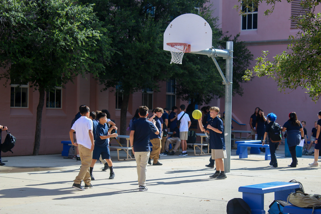 A group of students play basketball outside