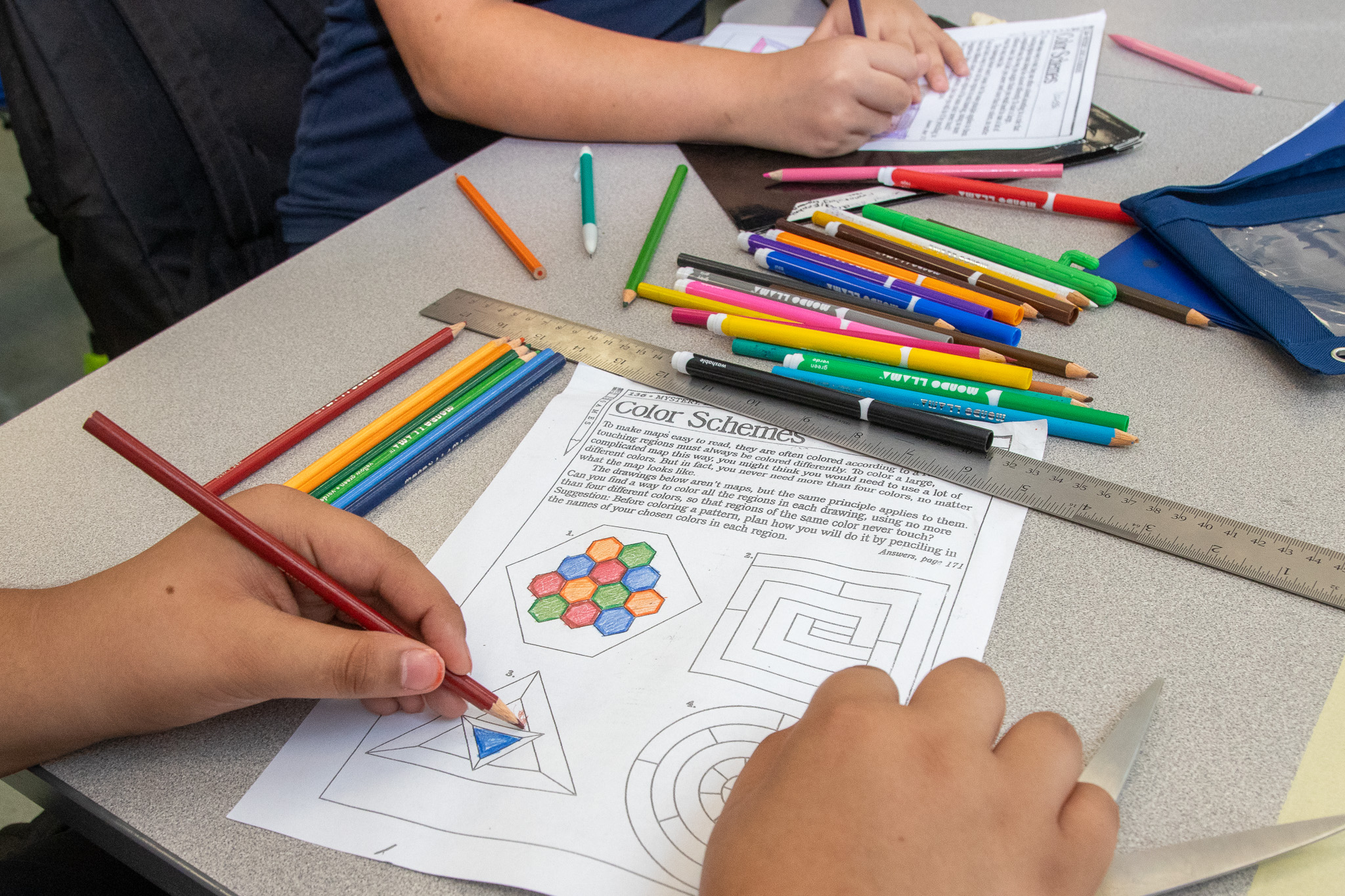 A student works on coloring in a worksheet