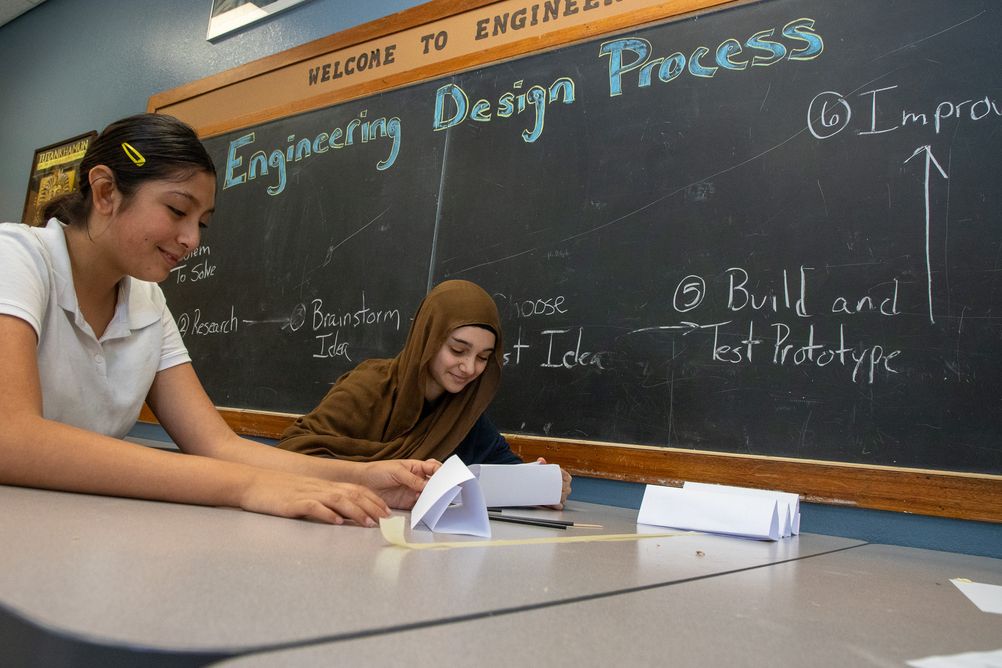 Two preteen girls work on a science project