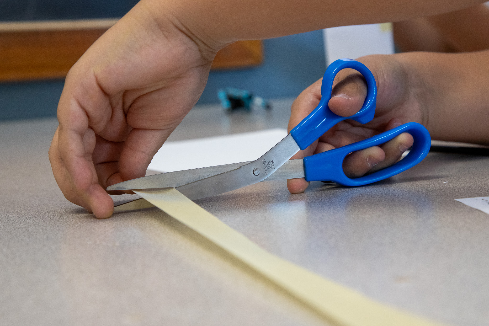 Closeup of a student cutting a piece of masking tape